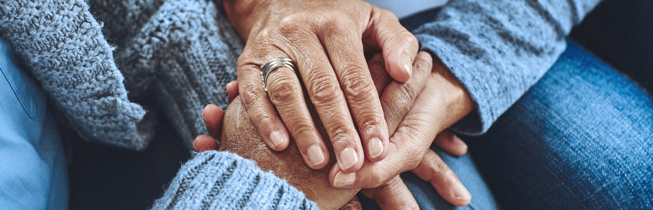 Omsorgsgiver holder på hendene til sin kjære