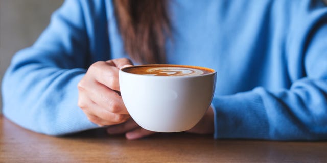 Nærbilde av person som løfter kaffekopp